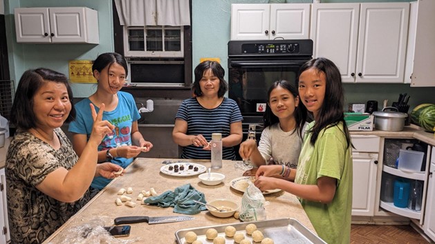 A group of women and girls cooking in a kitchen